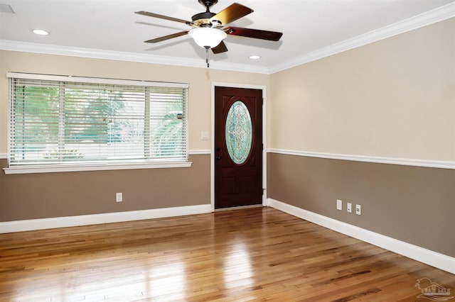 entryway with crown molding, wood-type flooring, and ceiling fan