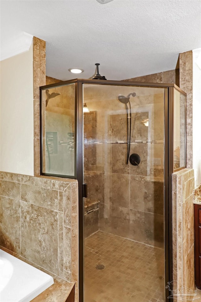 bathroom featuring vanity, separate shower and tub, and a textured ceiling