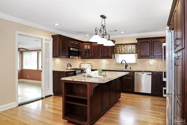 kitchen with a kitchen island, appliances with stainless steel finishes, dark brown cabinets, and sink