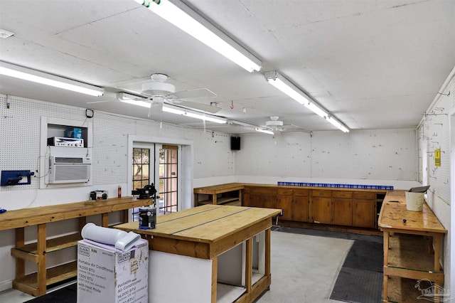 misc room with cooling unit, concrete floors, ceiling fan, and a workshop area