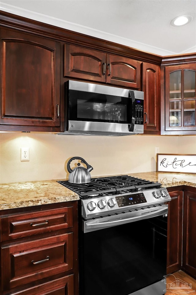 kitchen with light stone countertops and appliances with stainless steel finishes