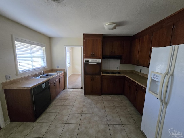 kitchen with backsplash, sink, dishwasher, oven, and white fridge with ice dispenser