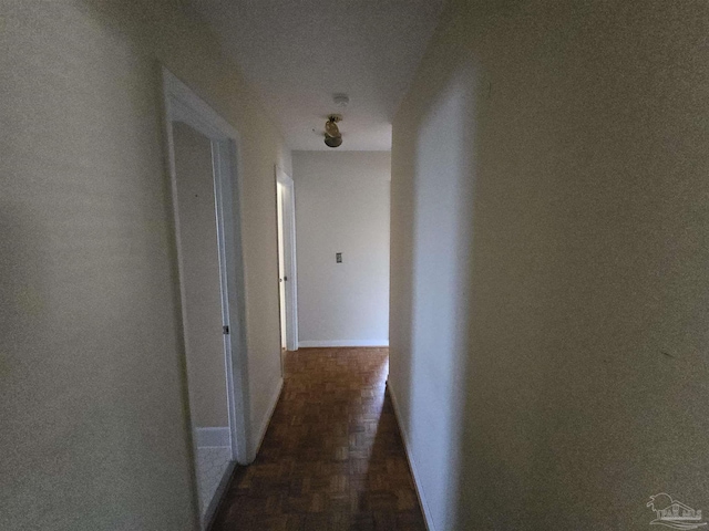 hallway featuring a textured ceiling and dark wood-type flooring