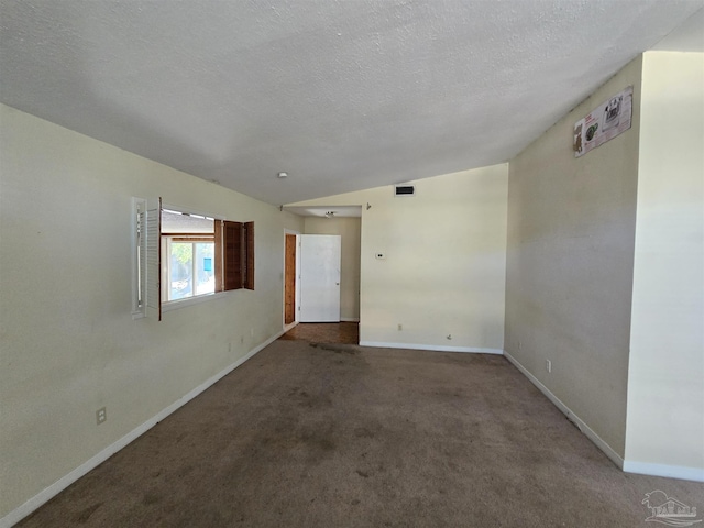 carpeted empty room with a textured ceiling and lofted ceiling