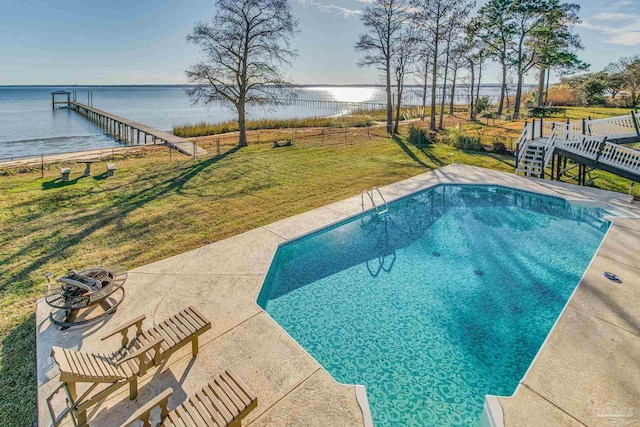 view of swimming pool with a lawn and a water view