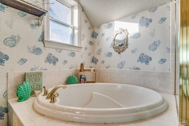 bathroom featuring a textured ceiling and tiled bath