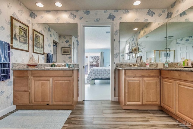 bathroom with hardwood / wood-style flooring, an enclosed shower, and vanity