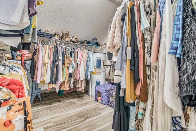 walk in closet with light hardwood / wood-style floors and water heater