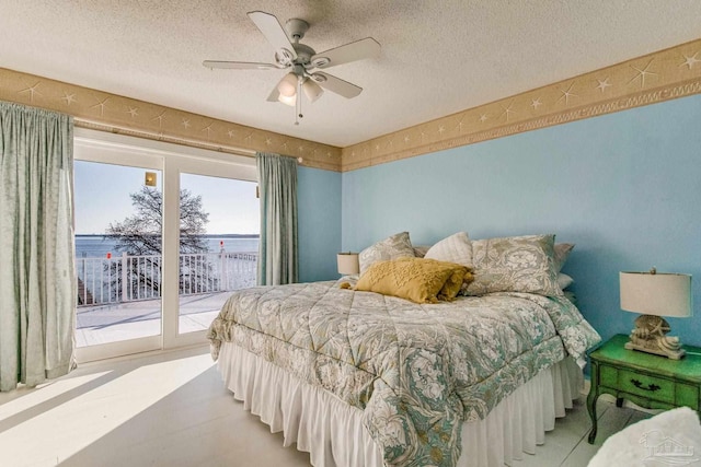 bedroom featuring access to exterior, ceiling fan, and a textured ceiling