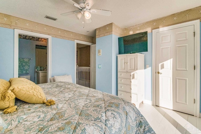 bedroom featuring ceiling fan, a textured ceiling, and ensuite bathroom