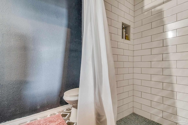 bathroom featuring toilet and curtained shower