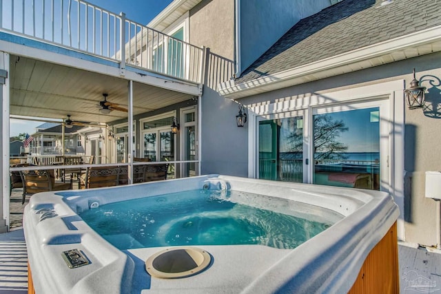 view of patio with ceiling fan, a balcony, and a hot tub