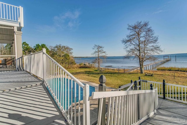 wooden deck with a pool, a lawn, and a water view