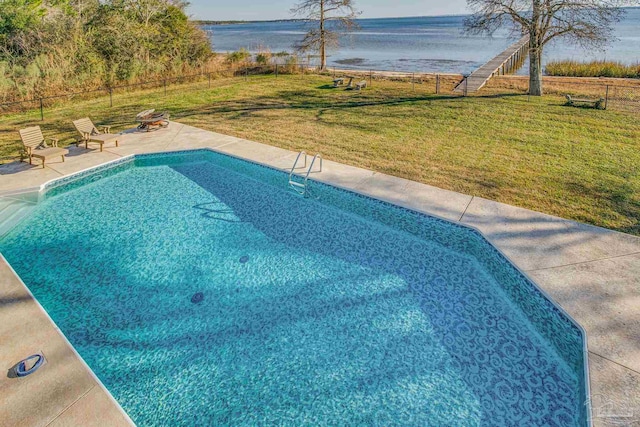 view of swimming pool featuring a water view, a yard, and a patio area