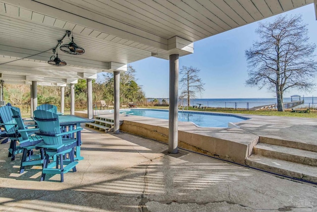 view of pool with a patio, a water view, and ceiling fan