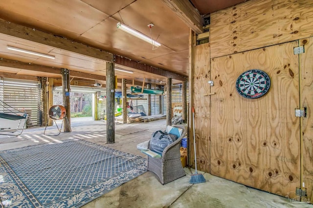 interior space featuring wood walls and concrete floors