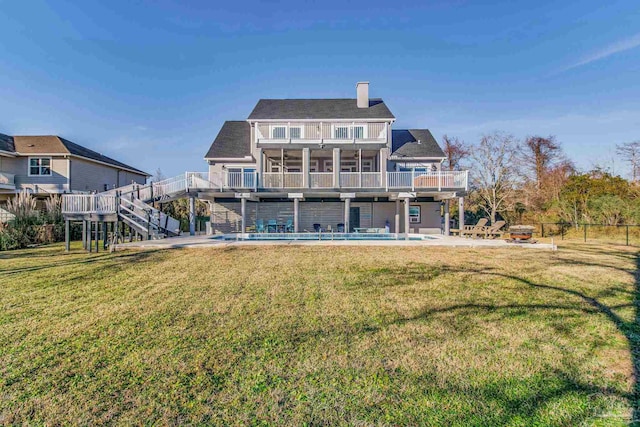 back of house featuring a sunroom, a patio, a lawn, a balcony, and a pool side deck