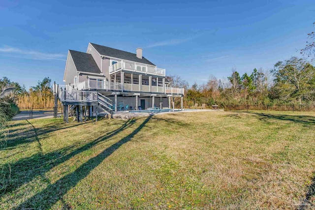 back of house featuring a deck, a balcony, a yard, and a patio area