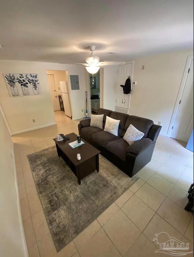 living room with ceiling fan, light tile patterned floors, and electric panel