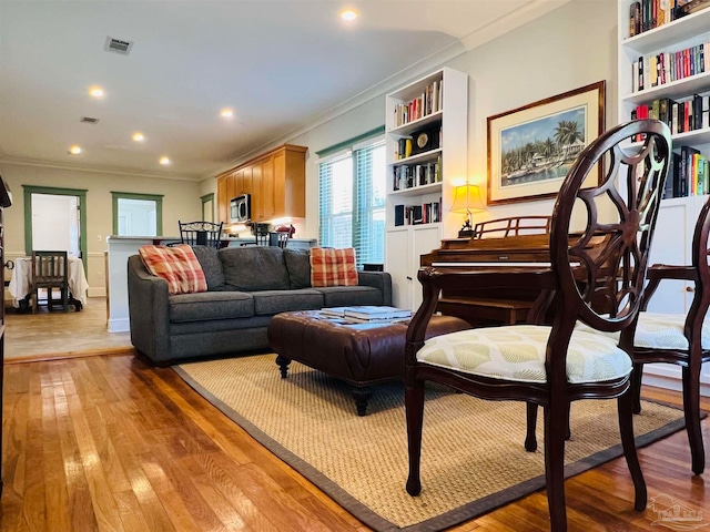 living room with crown molding and light hardwood / wood-style floors