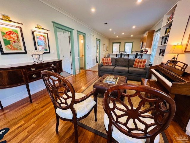 living room featuring crown molding and light hardwood / wood-style flooring