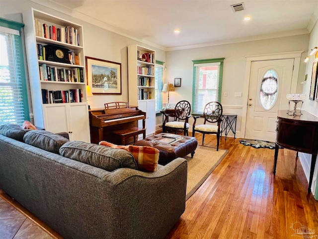 sitting room featuring ornamental molding, hardwood / wood-style flooring, and a healthy amount of sunlight