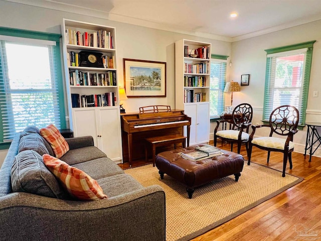 sitting room with light hardwood / wood-style flooring, ornamental molding, and a healthy amount of sunlight