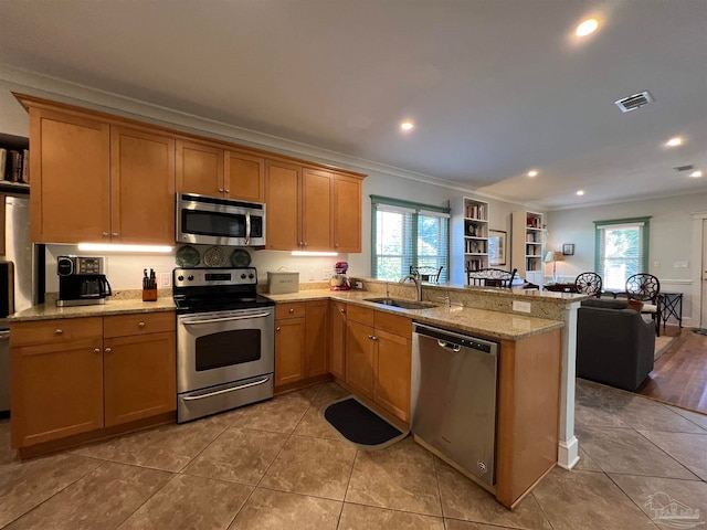 kitchen featuring kitchen peninsula, stainless steel appliances, sink, and plenty of natural light