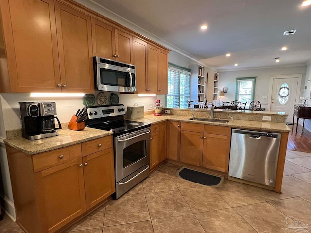 kitchen featuring kitchen peninsula, stainless steel appliances, ornamental molding, sink, and light tile patterned floors