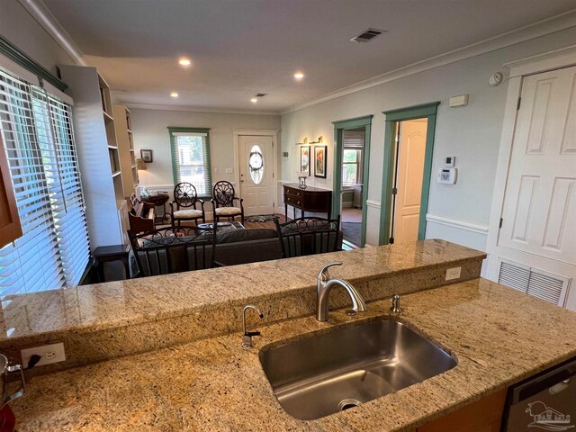 kitchen featuring stainless steel dishwasher, ornamental molding, sink, and light stone countertops