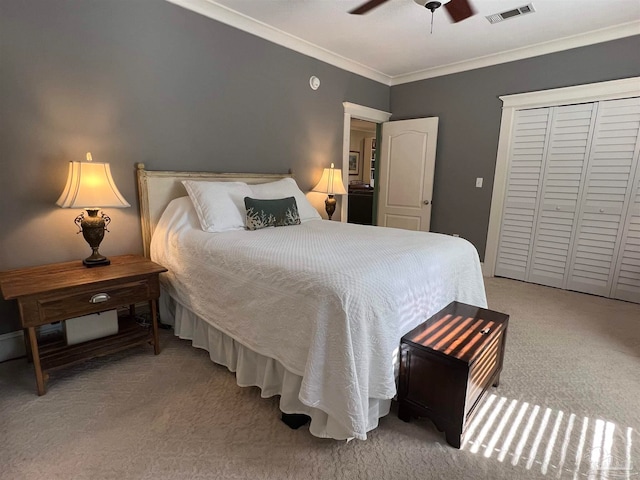 bedroom featuring ornamental molding, light carpet, a closet, and ceiling fan