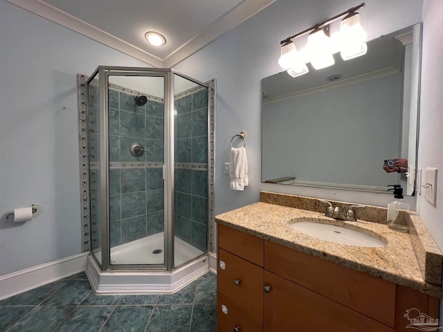 bathroom featuring a shower with door, vanity, crown molding, and tile patterned flooring