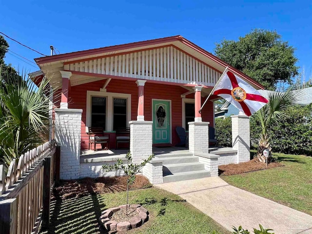 view of front of property with covered porch and a front yard