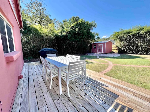 wooden deck with a storage unit and a lawn