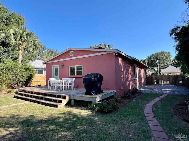 back of property featuring a yard and a wooden deck