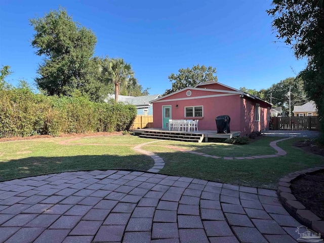 back of house with a patio, a wooden deck, and a lawn