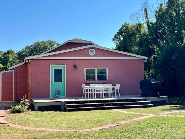 back of house with a wooden deck and a lawn