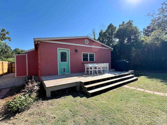 rear view of house featuring a yard and a deck