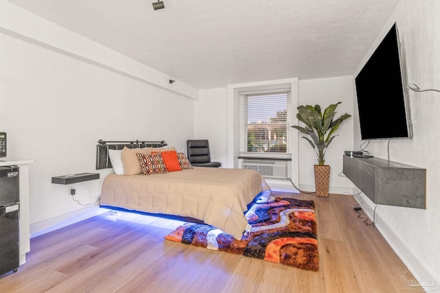 bedroom featuring a textured ceiling and light hardwood / wood-style floors