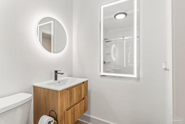 bathroom with vanity, a shower, and toilet