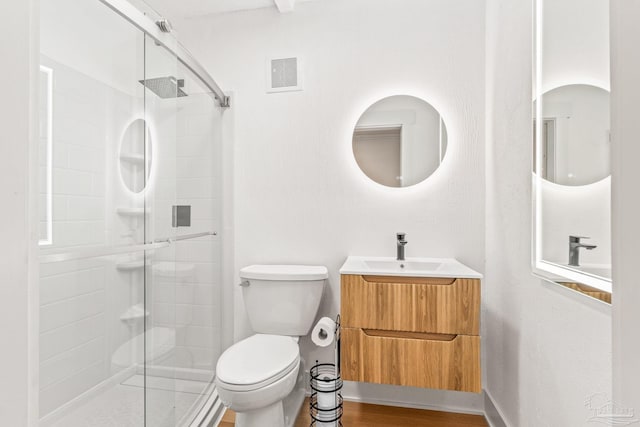 bathroom featuring walk in shower, vanity, toilet, and hardwood / wood-style flooring