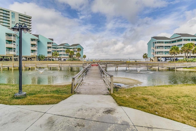 dock area featuring a water view and a lawn