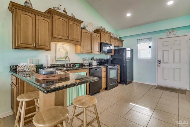 kitchen with light tile patterned floors, sink, dark stone countertops, black appliances, and vaulted ceiling