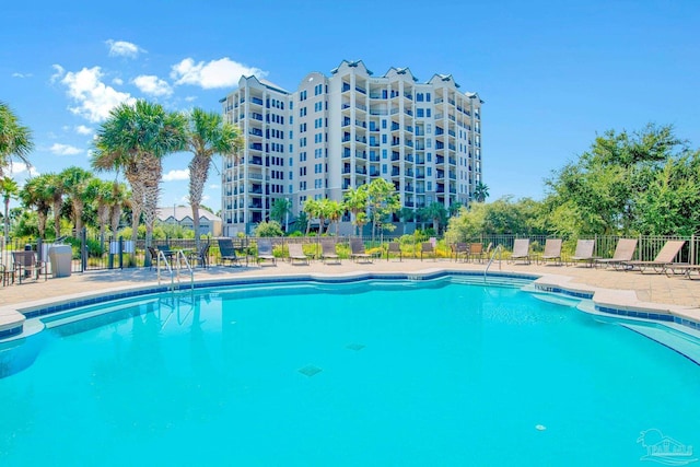 pool with a patio area and fence