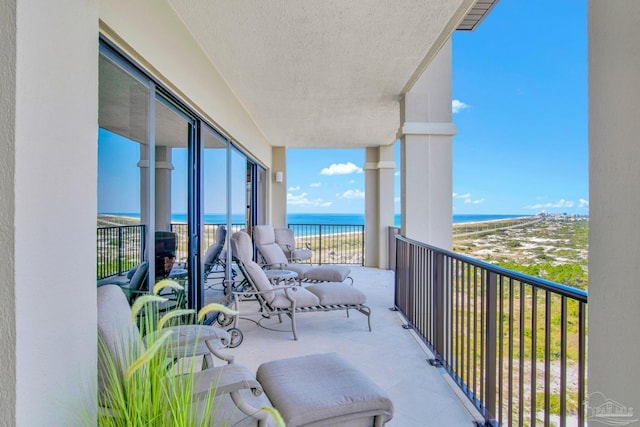 balcony featuring a beach view, a water view, and visible vents