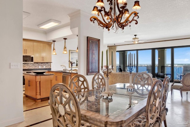 dining room featuring ceiling fan with notable chandelier, crown molding, sink, a textured ceiling, and light tile patterned floors