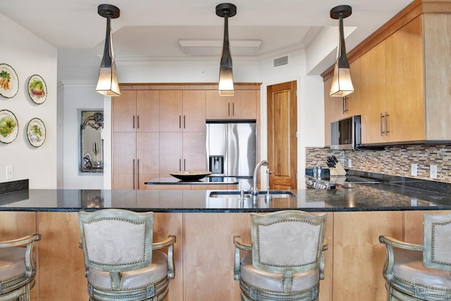 kitchen featuring a peninsula, a sink, visible vents, stainless steel fridge with ice dispenser, and decorative backsplash