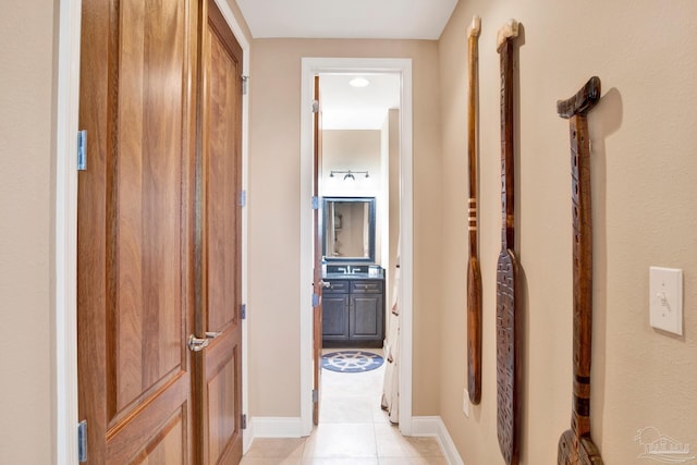 hallway featuring baseboards and light tile patterned floors