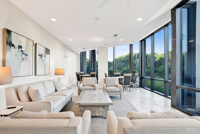 tiled living room featuring ceiling fan and a wall of windows