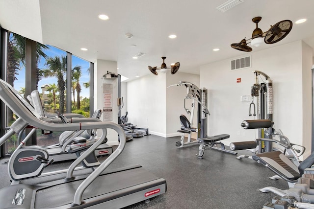 gym with baseboards, visible vents, a wall of windows, and recessed lighting